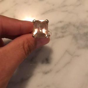 Silver tone ring with pink square stone.